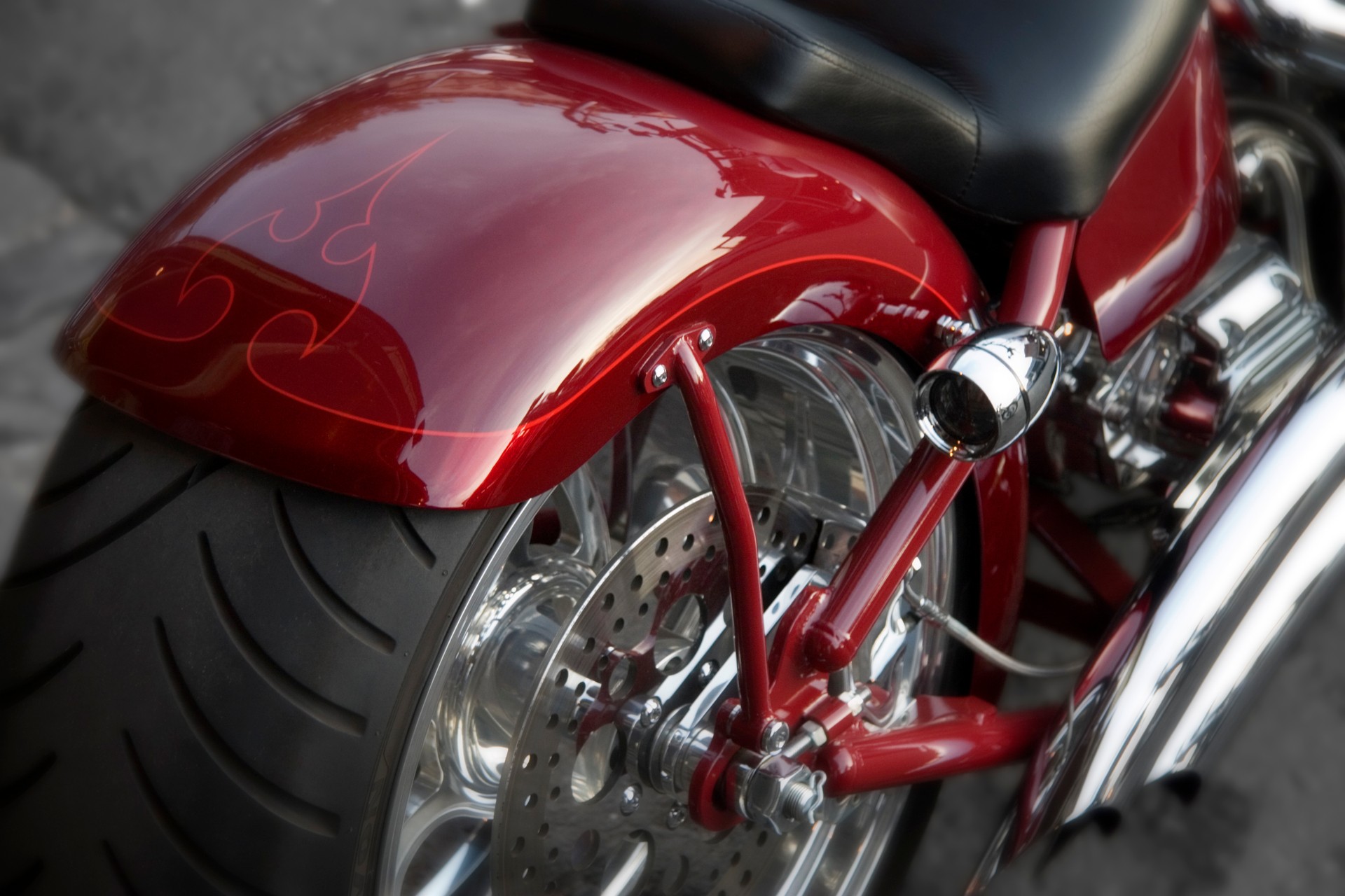 Close up photo of a rear motorcycle tire on a red chassis